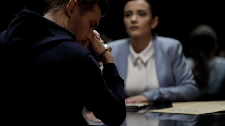 A handcuffed man at a table