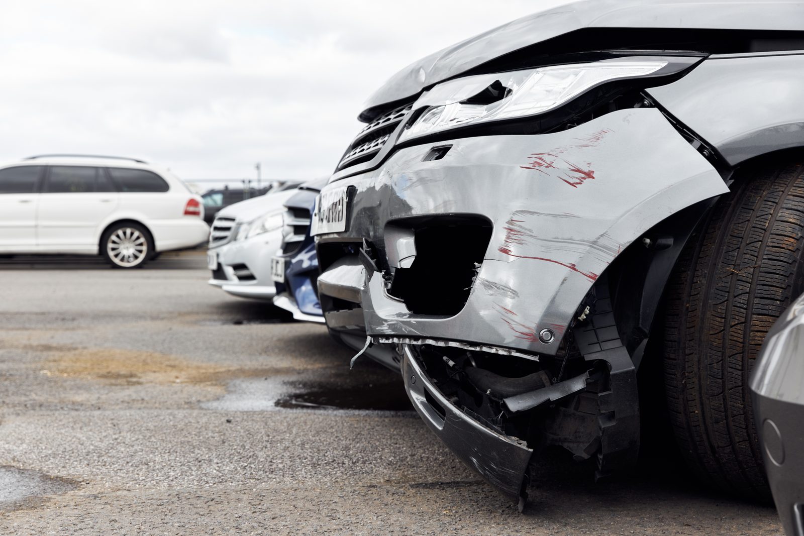Damaged front bumper on a vehicle in a parking lot
