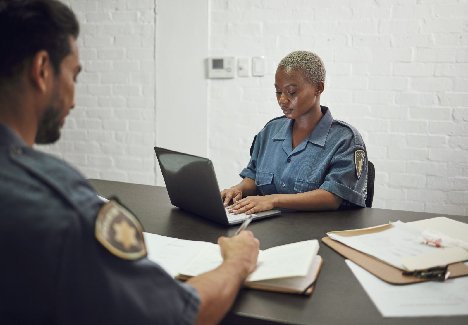 Officers reviewing case documents at a desk