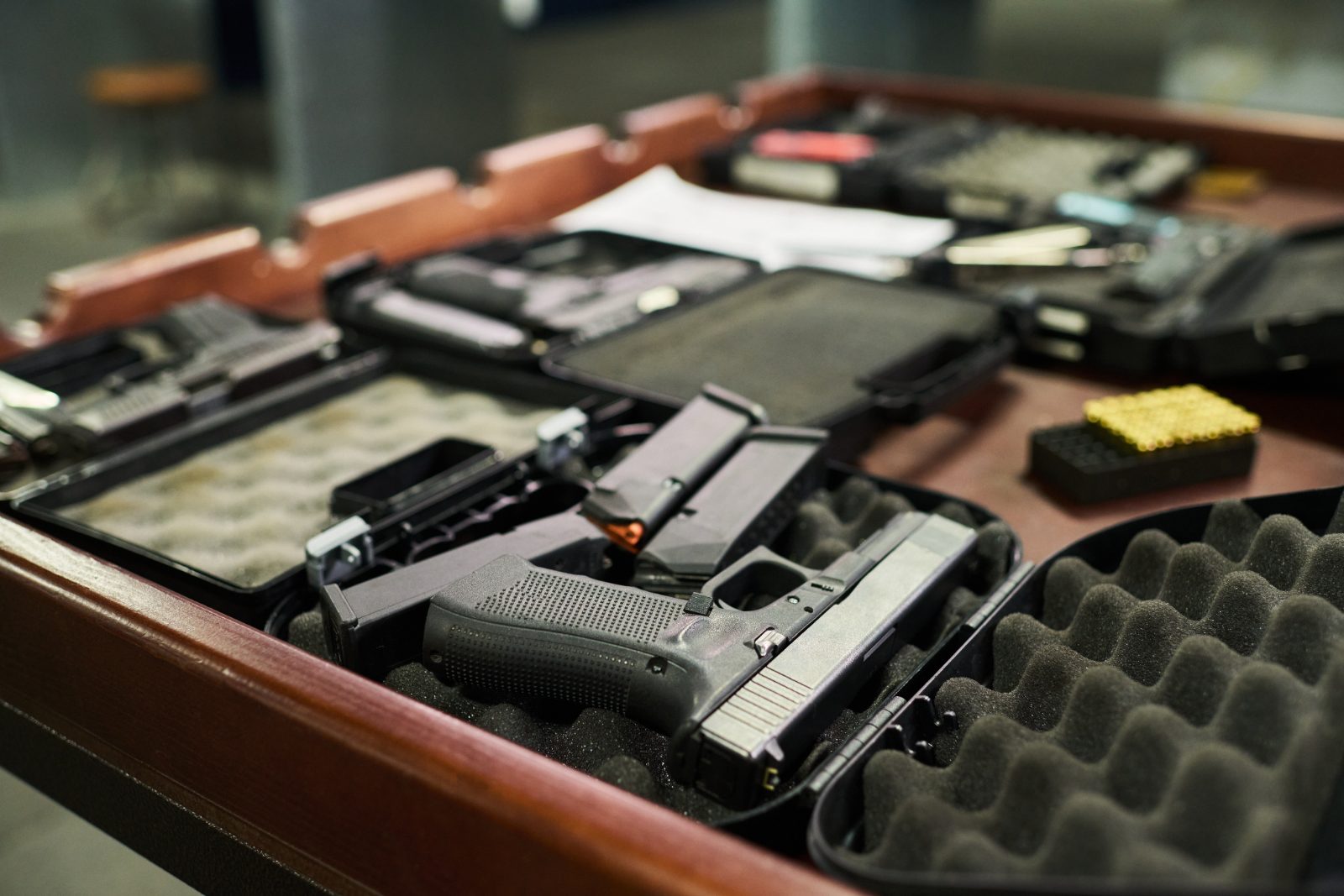 Handguns and ammunition in open cases on a table